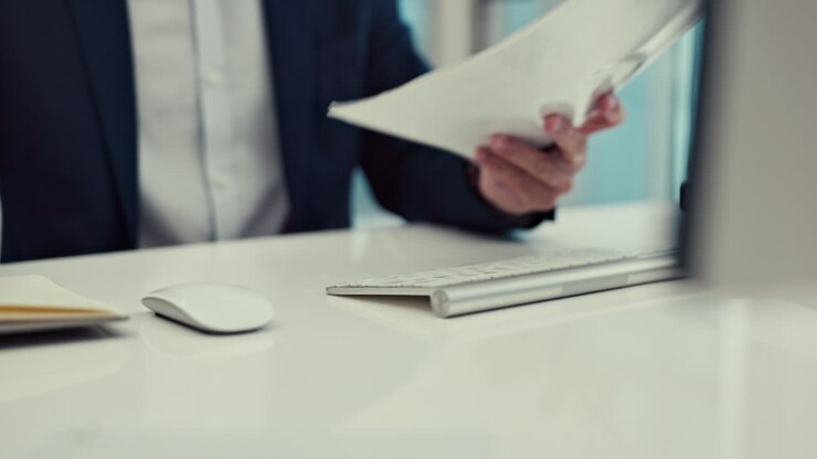 Hands, documents and a business man typing