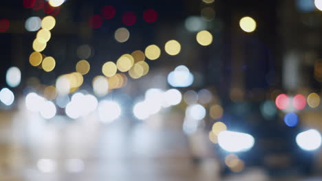 unsharp traffic lights of cars with bokeh on streets of illuminated city