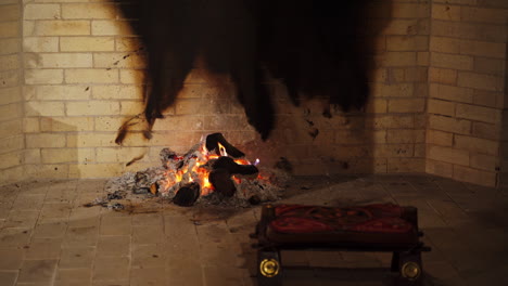 romantic fire in fireplace. smoldering logs on pile of ash in home mantel. burning-out wooden logs. burning wood in fireplace in winter.