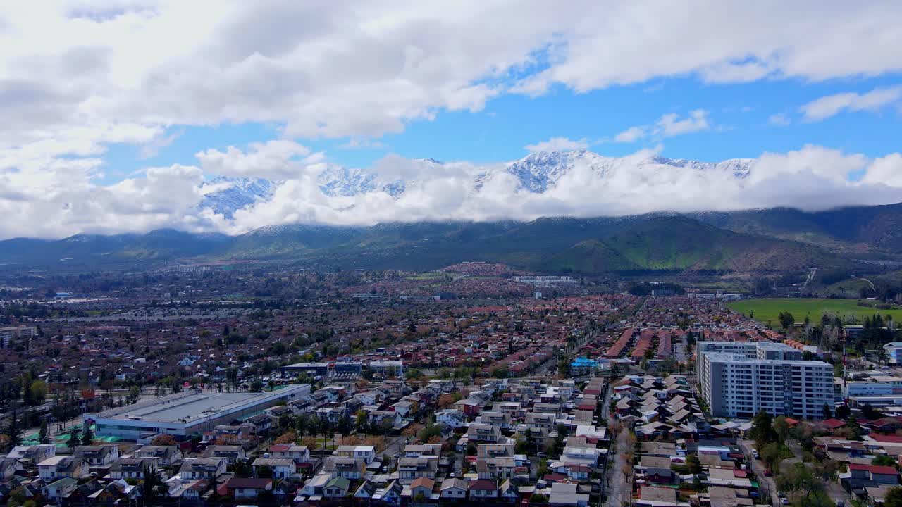 Chuyến bay trên không hướng tới dãy núi Andes phủ tuyết hùng vĩ bị mây che phủ một phần, để lộ các khu dân cư và tòa nhà hiện đại trải dài khắp thung lũng. Santiago, Chile