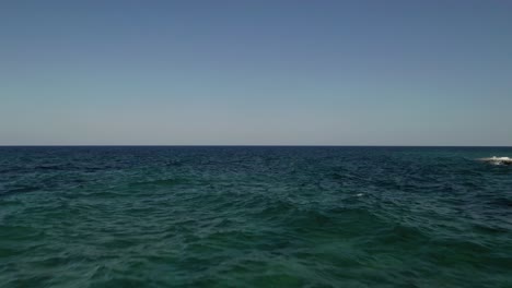 Aerial-drone-footage-flying-very-low-above-sea-level-close-to-bright-sandstone-rocks