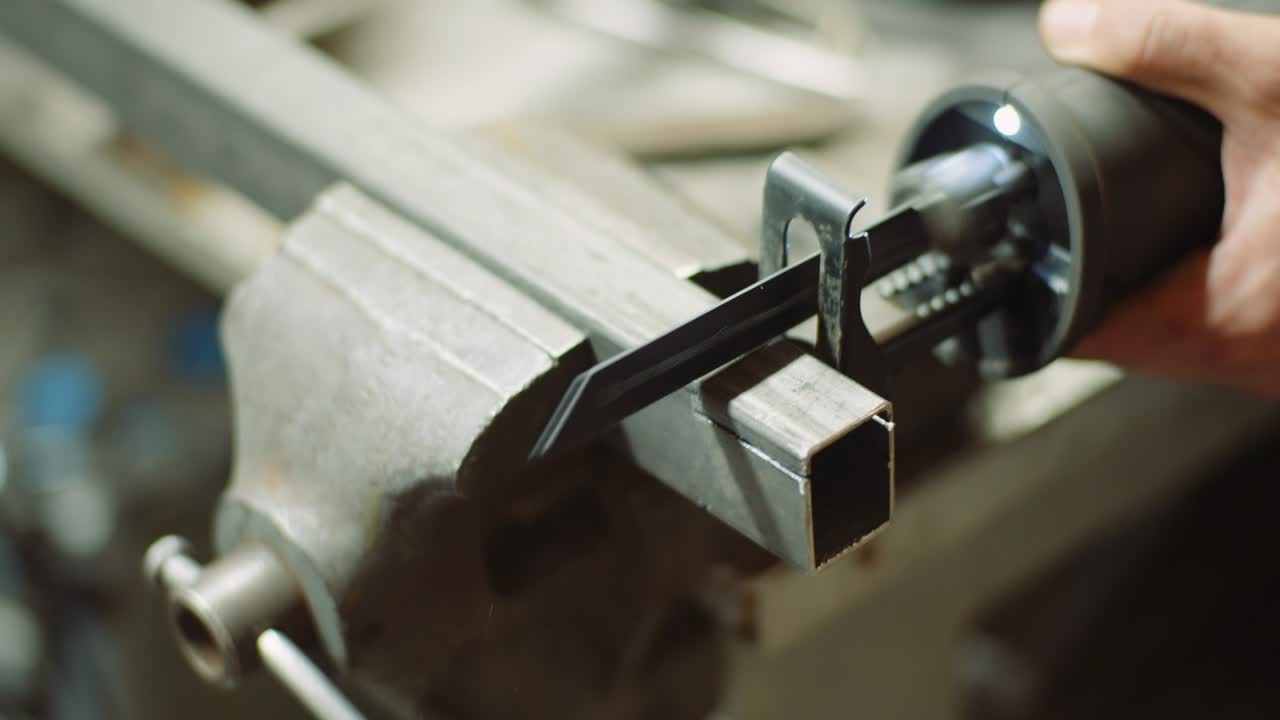 trabajador de la industria de piezas metálicas con sierra eléctrica