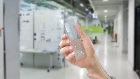 Hand-holding-futuristic-mobile-phone-in-office