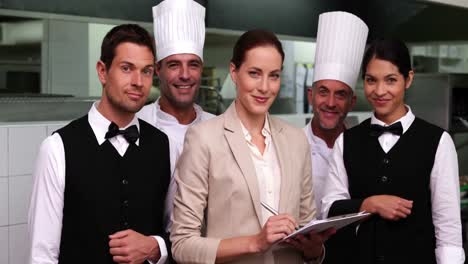 Happy-restaurant-staff-with-manager-smiling-at-camera