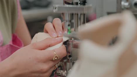 hands guide shoe as machine perforates eyelets with precision
