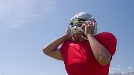 american football player putting on his helmet