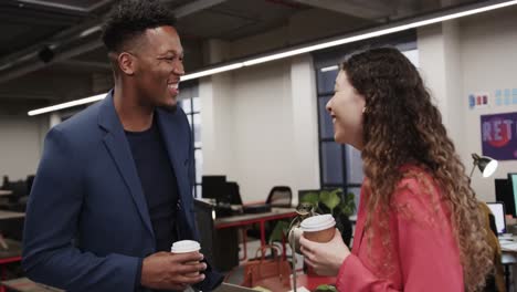 two happy diverse creative colleagues in discussion in casual office, slow motion