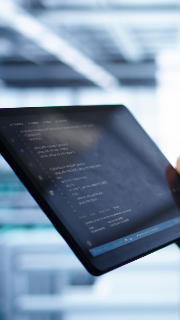 Close-Up of Hand Scrolling Through Code on a Tablet Screen