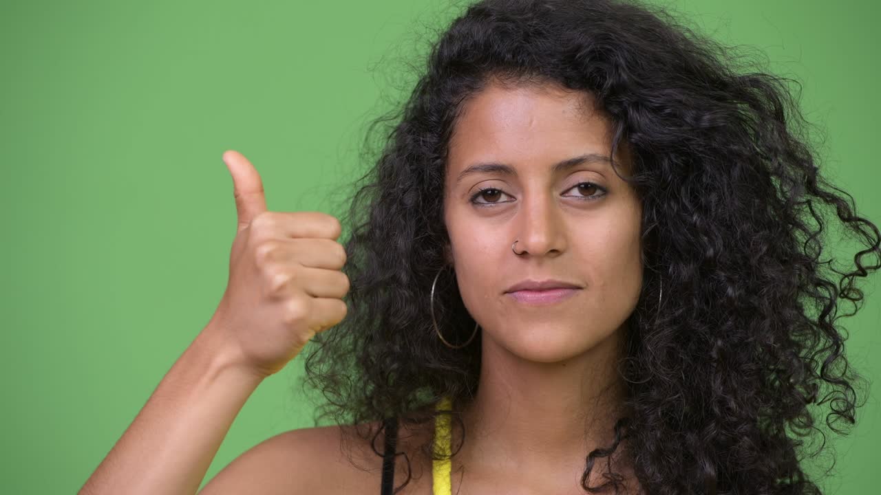 Young beautiful Hispanic woman giving thumbs up
