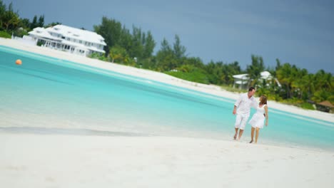 caucasian couple walking together on tropical vacation beach