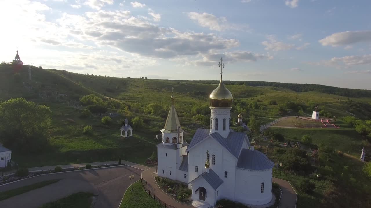 белый храм с куполами в горах летом