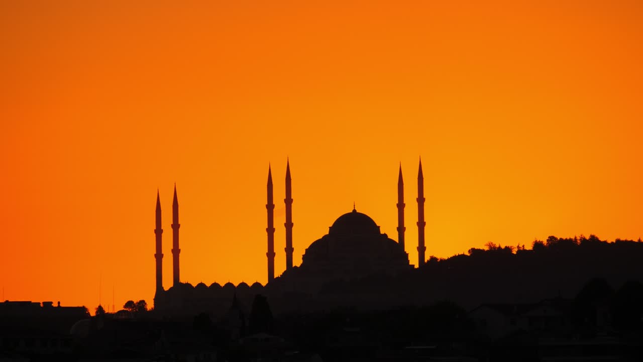 Camlica Mosque silhouette against orange sky, just before sun shows up