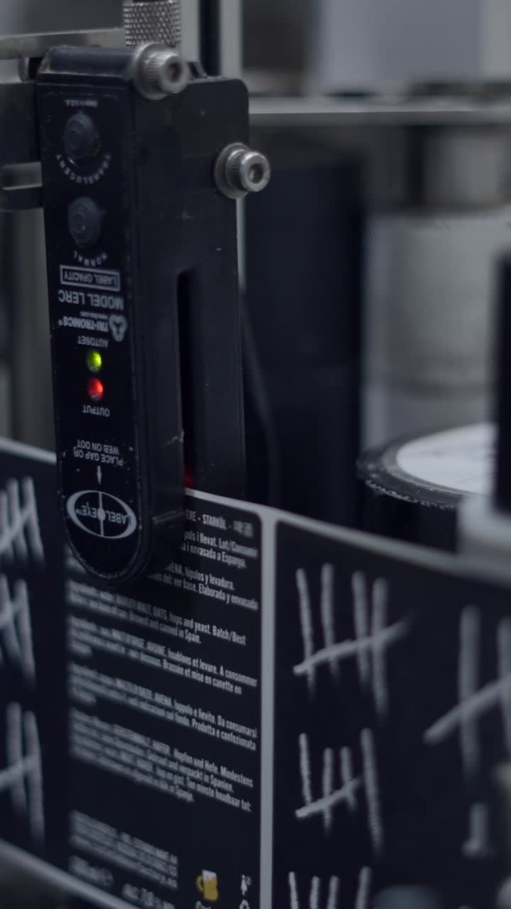 Close-up of an industrial labeling machine with a sensor