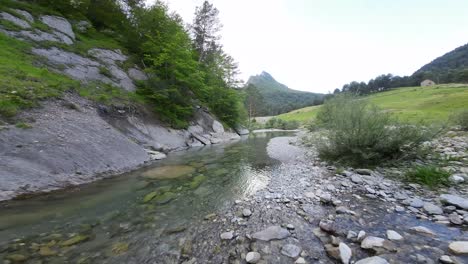 immagine aerea di un drone che vola sopra un fiume in una zona montuosa