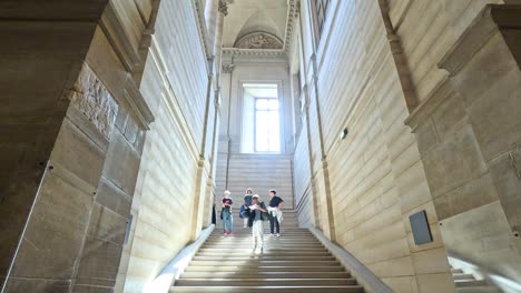 people walking down stairs in louvre museum