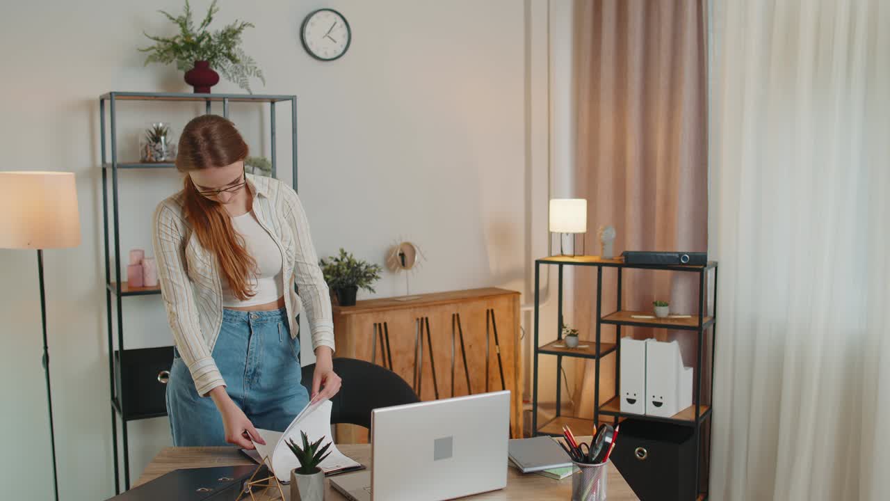 집 사무실에서 책상 에 서서 서류를 분석하고 체크 데이터를 분석하는 젊은 여성