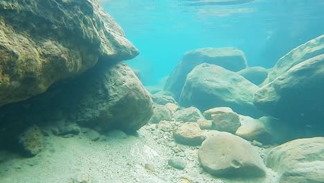 Felsen-Am-Wasserfallboden-Mit-Klarem,-Blauem-Wasser-Am-Tag-Von-Vorne