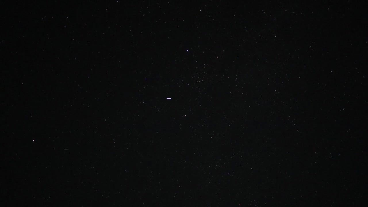Vídeo em timelapse de estrelas se movendo pelo céu noturno escuro, revelando o movimento sutil da paisagem celestial ao longo do tempo. Uma cena de astronomia pacífica ideal para temas de espaço, observação de estrelas e noite