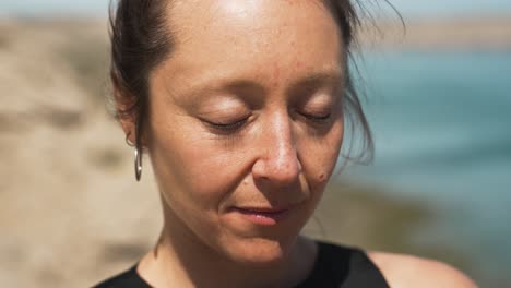 mujer en postura de pranamasana yoga con fondo de paisaje oceánico - vertigo zoom shot