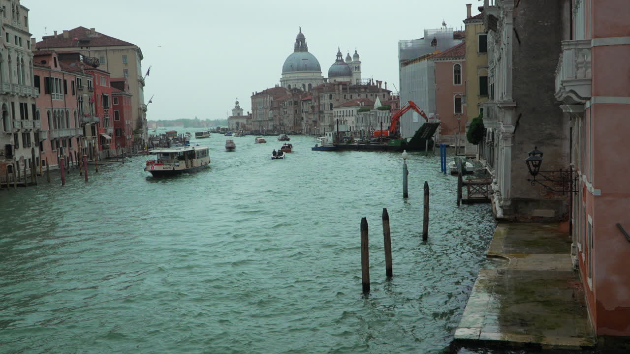 Grand Canal of Venice with boats passing on a cloudy day, establisher shot