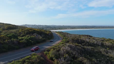 Filmische-Drohnenaufnahme-Einer-Malerischen-Straße-Entlang-Der-Küste-Westaustraliens-Bei-Sonnenuntergang-Mit-Fahrenden-Autos