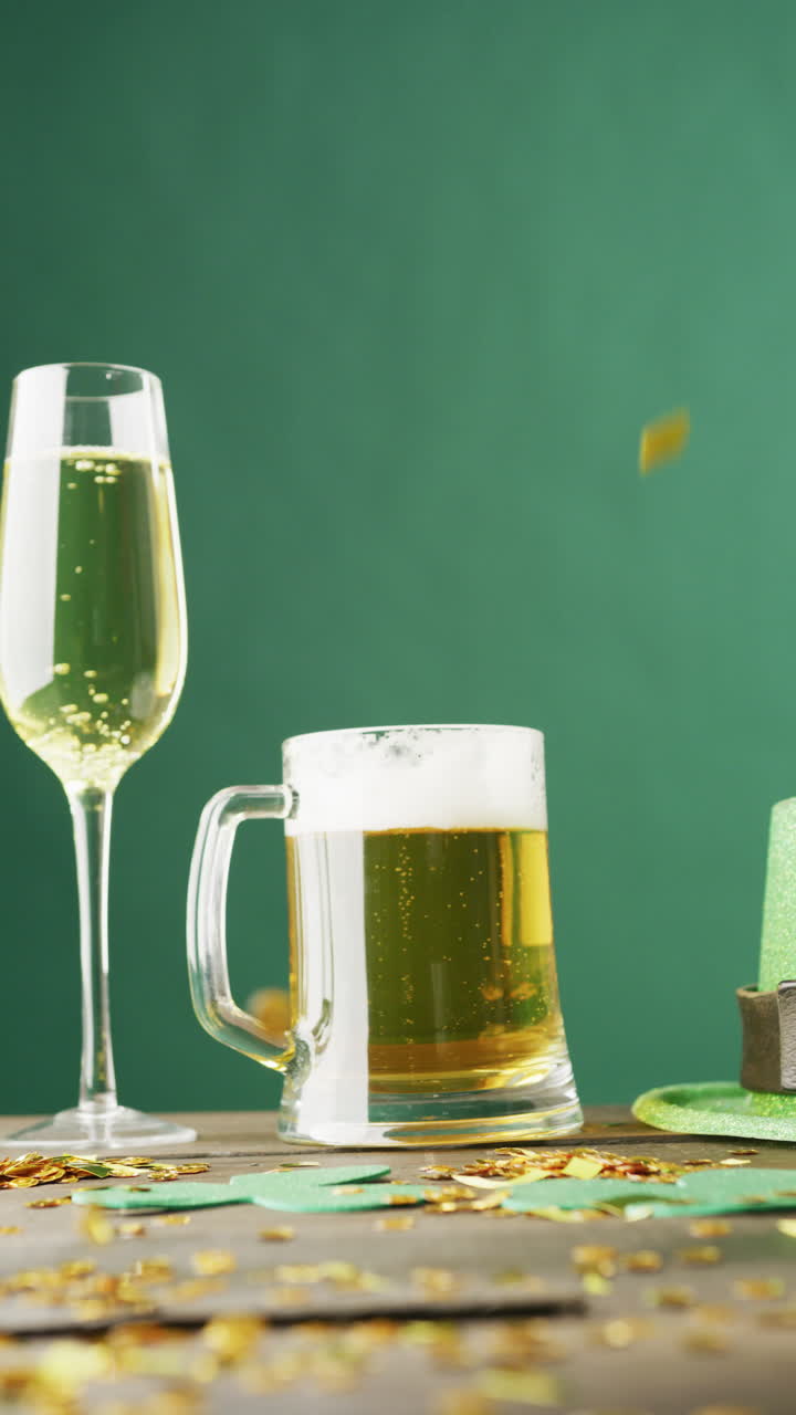 Vertical video of of st patrick's green hat, beer and champagne glasses on green background