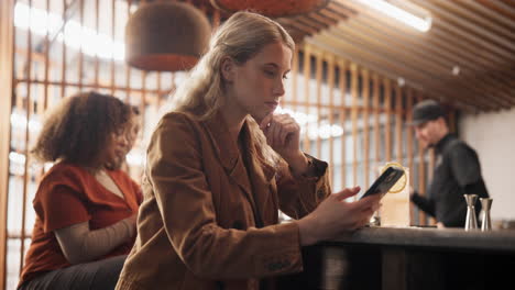 mujer usando el teléfono en un bar