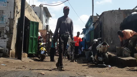 man pushing cart in raft road of dakar, still shot low angle