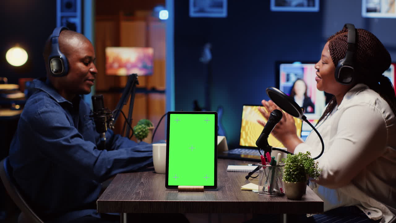 tableta de pantalla verde frente al anfitrión del programa grabando podcast, disfrutando de una buena conversación con el invitado