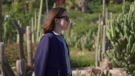 toma panorámica de una joven caminando por los jardines botánicos mossen costa llobera barcelona españa