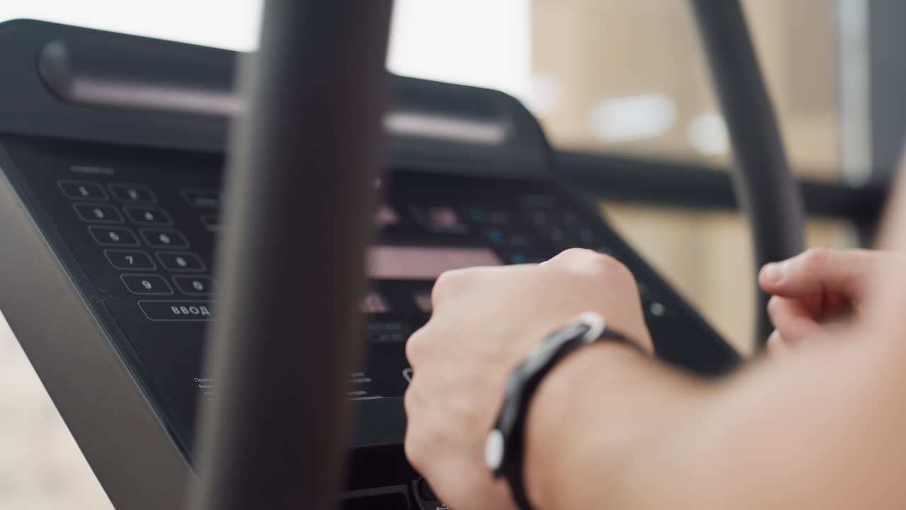 Console display on treadmill shows active workout metrics including speed time distance heart rate while athlete grips handlebars with firm focus determination in modern bright gym environment