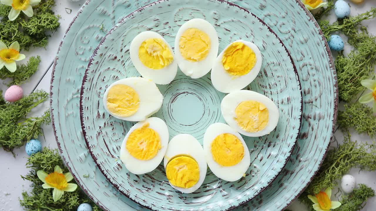 꽃과 계란이 있는 부활절 테이블 세팅 삶은 계란이 있는 장식 접시
