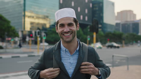 Retrato-De-Un-Joven-Exitoso-Del-Medio-Oriente-Sonriendo-Mirando-La-Cámara-Feliz-Disfrutando-Del-Estilo-De-Vida-Urbano-En-La-Ciudad-Usando-Sombrero-Kufi