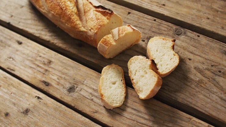 Video of baguette with four slices on a wooden surface