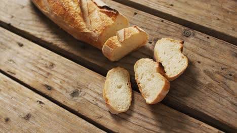 video of baguette with four slices on a wooden surface