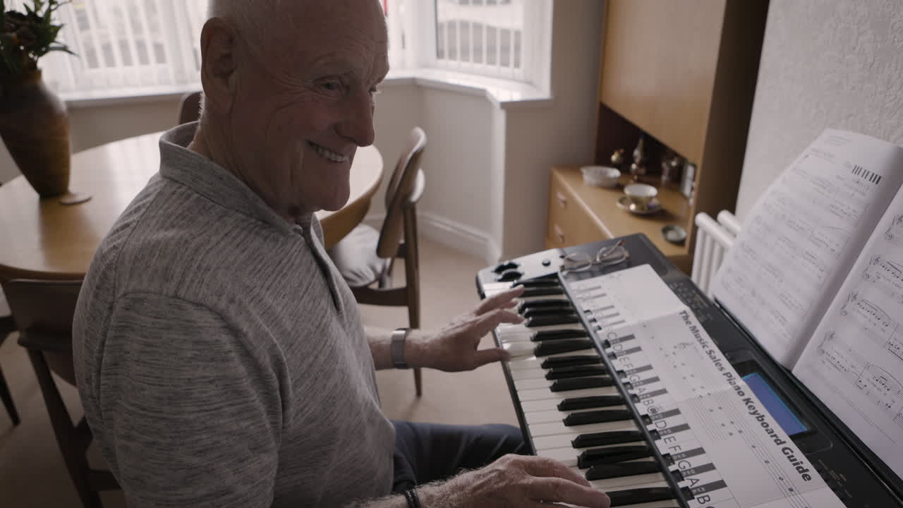 Elderly man playing the piano at home