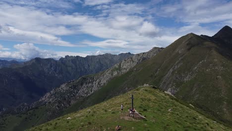 Panoramic-shot-of-people-that-reached-the-cross-at-the-mountaintop---Lake-Lago-Maggiore---North-of-Italy