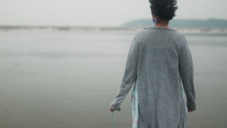 back view of a woman walking at the beach