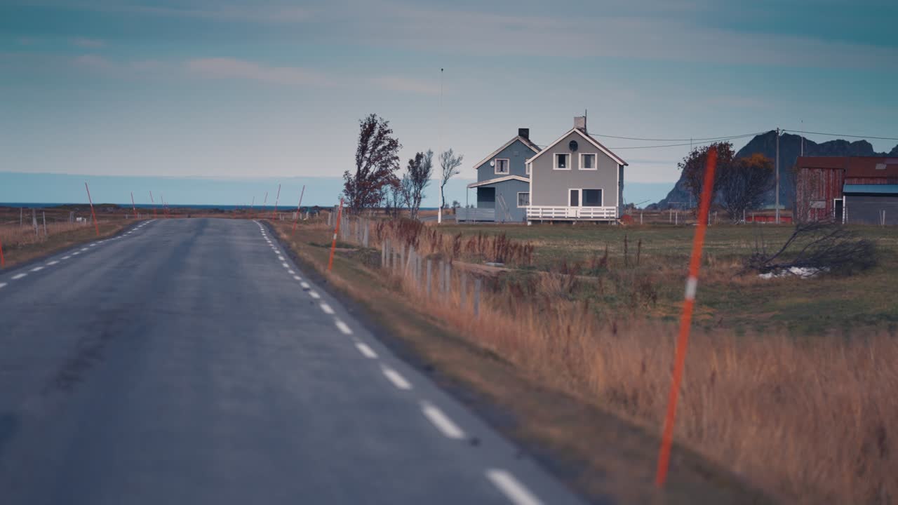 En smal landevej løber gennem det vindblæste nordlige landskab.