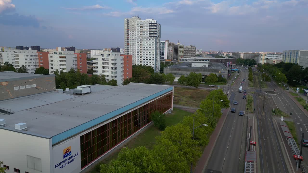 halle neustadt in germany, tramway station and the distinctive swimming pool building with its colorful mural. Amazing aerial view flight ascending drone