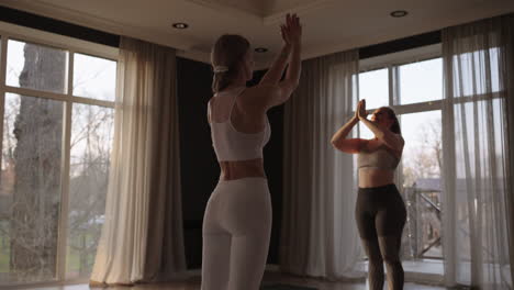 young caucasian sporty people practicing yoga lesson with instructor. caucasian group of women exercising healthy lifestyle in fitness studio. sport activity gymnastics class. slow motion.