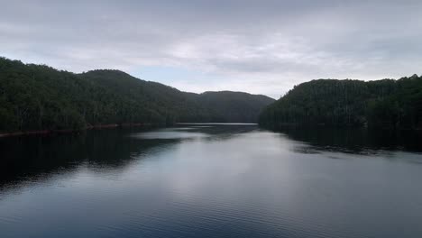 Atemberaubende-Luftaufnahme-Des-Lake-Barrington-Mit-Ruhigem-Wasser-An-Einem-Bewölkten-Tag-In-Der-Nähe-Von-Sheffield-In-Tasmanien,-Australien