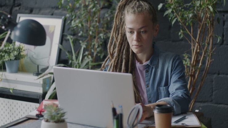 Woman Working on Laptop in a Coffee Shop