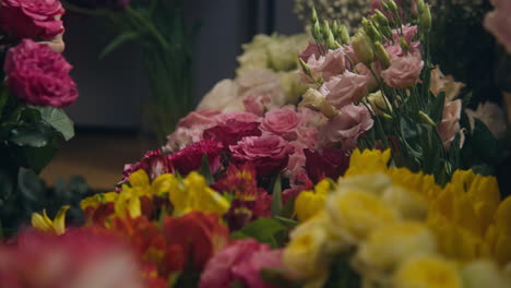 un florista masculino recoge un ramo para un cliente en una tienda de flores