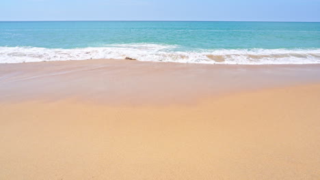 slow-motion of waves washing over a golden sand beach