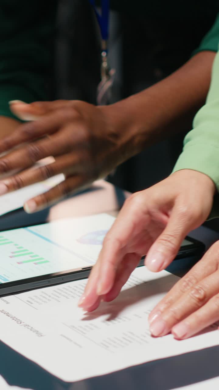 Vertical Video Diverse team members meeting after hours to share data reports