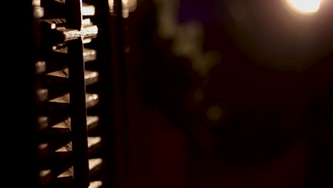 a small wooden cross hangs in the church with lighting on it - camera moving up