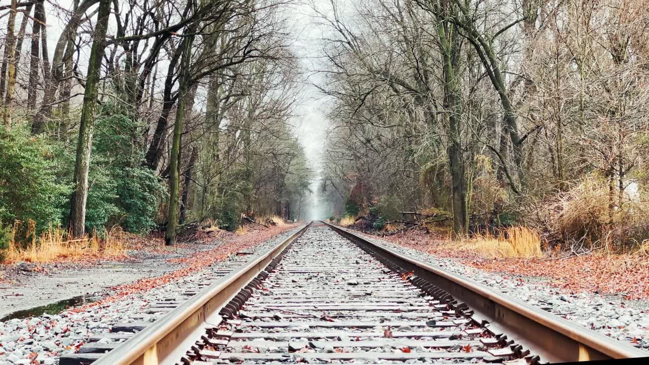 Low Establishing Winter Shot on Train Tracks Toward Foggy Horizon