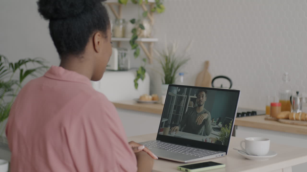 Woman having a video call with a man in a kitchen