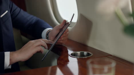 closeup passenger holding tablet in hands. stylish businessman touching screen